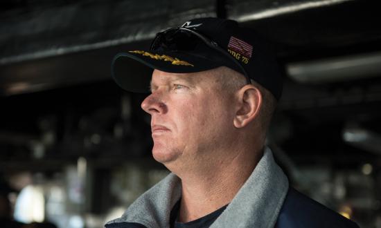 Commanding Officer of the USS Donald Cook (DDG-75) standing on the bridge.