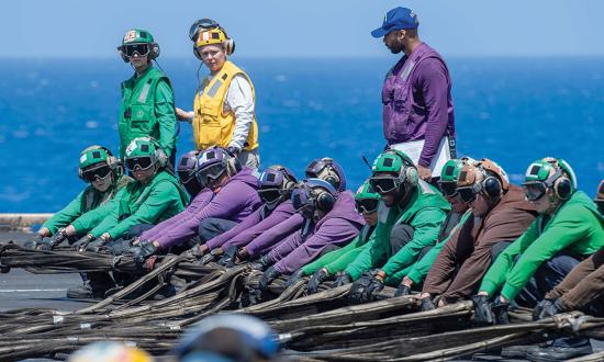 Flight deck crew on board the USS Dwight D. Eisenhower (CVN-69) work together to rig the barricade during a drill in the Mediterranean Sea in May 2024. Naval aviation is a team effort that requires hard work, persistence, and faith to deliver indispensable force around the globe.  