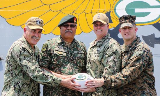 The opening of Tiger Strike 2019, USS Green Bay (LPD-20) commanding officer Captain Michael Harris, Rear Admiral Kacher, and Marine Lieutenant Colonel William Jacobs presented a Malaysian general a Green Bay Packers football as a memento.
