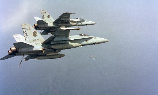 wo F/A-18A Hornet aircraft from Strike Fighter Squadron 192 (VFA-192), bank into a turn to approach the aircraft carrier USS MIDWAY (CV 41).