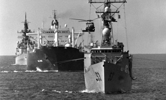 The guided missile frigate USS Hawes (FFG-53) leads the reflagged tanker Gas King, guided missile cruiser USS William H. Standly (CG-32) and an aircraft carrier through the Persian Gulf