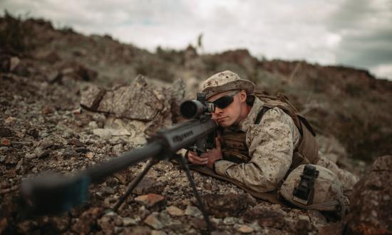 U.S. Marine Corps scout sniper looks down the scope of an M82 Special Applications Scoped Rifle