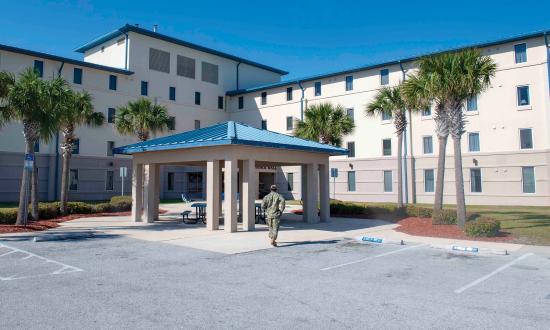 A sailor walks toward Delbert Black Hall, an unaccompanied housing quarters on Naval Station Mayport, Florida. Providing a better quality of life for junior sailors by improving their living quarters could increase retention and productivity.