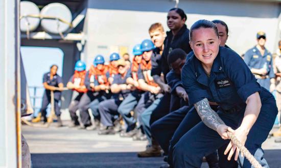 Information Systems Technician 3rd Class Jordan Greenberg heaves a line aboard the San Antonio-class amphibious transport dock ship USS Arlington (LPD-24) during a replenishment-at-sea