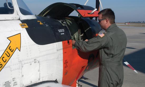 Chief Warrant Officer Michael S. Adams (shown here preflighting a T-34C at NAS Whiting Field) finished pilot primary flight training under the Active Duty Flying CWO Pilot Program. The program was discontinued in 2013.
