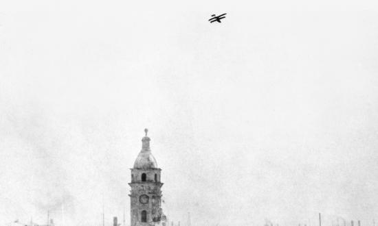 The Curtiss flying boat AB-3 soars over Vera Cruz as its pilot and observer search for enemy snipers on city rooftops during the U.S. intervention in the Mexican Revolution. 