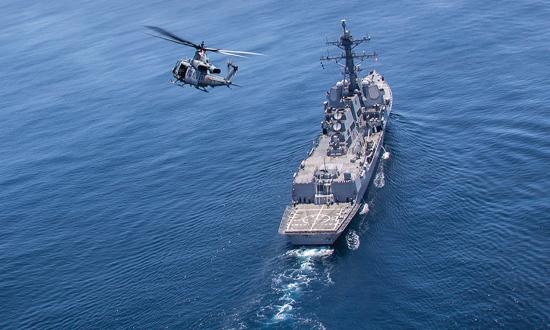 A Marine Corps UH-1Y Venom helicopter with Marine Light Attack Helicopter Squadron 469 flies over the USS John Finn (DDG-113). The teamwork of land, sea, and air forces and the central role of scouting—“information acquisition”—will be essential to littoral combat in the western Pacific and anywhere else the Navy and Marine Corps must team up to fight.