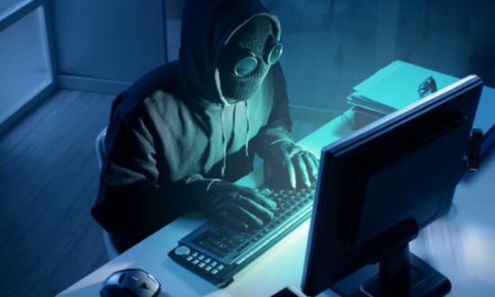 Masked hacker at a computer