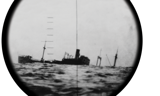 A sinking Japanese ship seen through the periscope of a U.S. submarine.