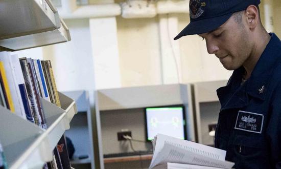 A sailors examines the library on the USS Anchorage (LPD-23)