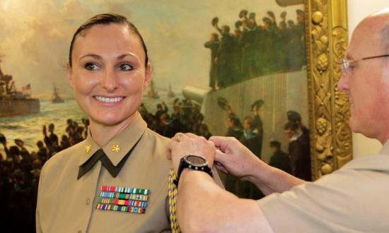 Chief of Naval Operations Admiral Michael M. Gilday attaches the aiguillette to the shoulder of Major Lauren Serrano at the beginning of her tour as his Marine aide-de-camp.