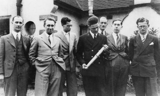 Midshipman Truax, holding an experimental liquid-fuel rocket motor, poses with members of the British Interplanetary Society in July 1938.
