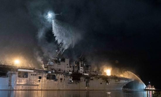 A helicopter for Helicopter Sea Combat Squadron 3 combats the fire on board the USS Bonhomme Richard (LHD-6) on 14 July.