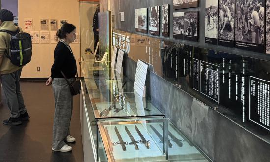 Museumgoers view an exhibit showing artifacts excavated from the tunnel complex and describing the battle.