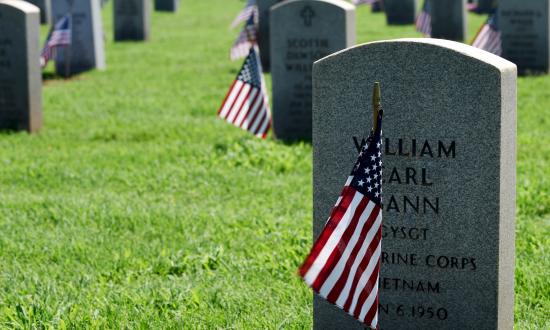 U.S. flags beside the graves of deceased military members at the Texas State Veterans Cemetery in Abilene, Texas on Memorial Day, 2018.