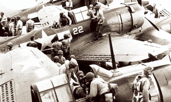 Pilots and gunners of Bombing Squadron 16 (VB-16)  climb out of their Douglas SBD-5 bombers onto the flight deck of the USS Lexington after returning from the Tarawa-Makin raid, 18 September 1943.