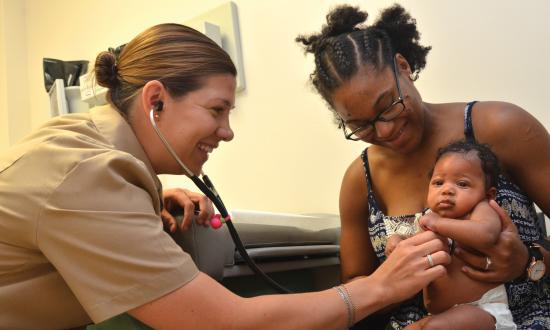 Lt. Allison Wessner, a pediatrician at Naval Hospital Jacksonville, conducts a check-up with a two-month-old and her mother.