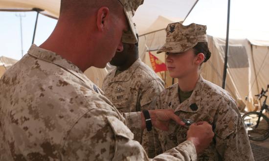 a Navy corpsman is presented with her Fleet Marine Force Warfare Specialist pin during a ceremony