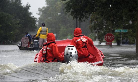 Coast Guardsmen pilot a 16-foot flood punt boat and join good Samaritans in patrolling a flooded neighborhood in Friendswood, Texas