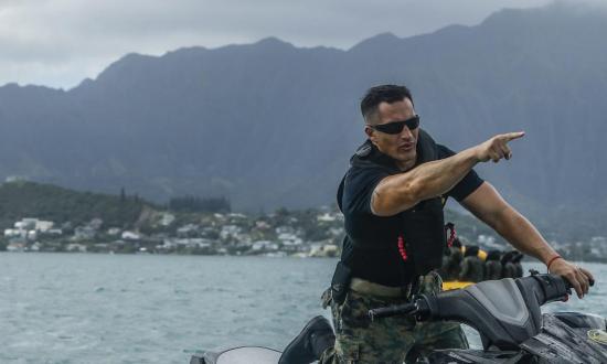 Marine gunnery sergeant directs his Marines from a jetski during a water rescue training event off the shore of Marine Corps Base Hawaii