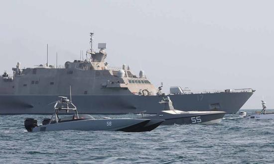 The USS Indianapolis (LCS-17) sails with unmanned surface vessels in the Arabian Gulf. Rather than decommissioning the littoral combat ships, the Navy should install the lethality and survivability upgrades that have been proposed.