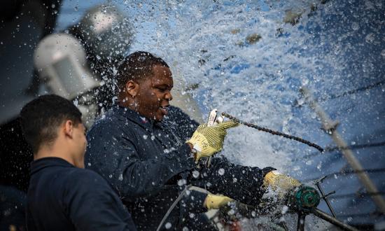 Machinist Mate 2nd Class Dezmond Twymon of the USS Porter (DDG-78) patches a ruptured pipe during the Porter’s damage control olympics in 2018