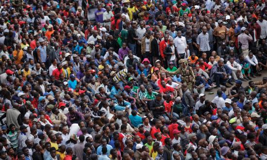 An army soldier, centre right, pleads with thousands of protesters demanding President Robert Mugabe stand down, to keep their calm and not try to surge forward, as they gather behind an army cordon on the road leading to State House in Harare, Zimbabwe Saturday, Nov. 18, 2017