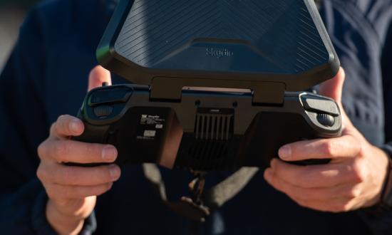 A U.S. Coast Guard member controls an unmanned aircraft system from its controller. Integrating unmanned assets into Coast Guard operations and arming the skilled workforce with state-of-the-art autonomous technology enables every cutter, small boat station, and sector to effect operations with heightened efficiency and precision. 