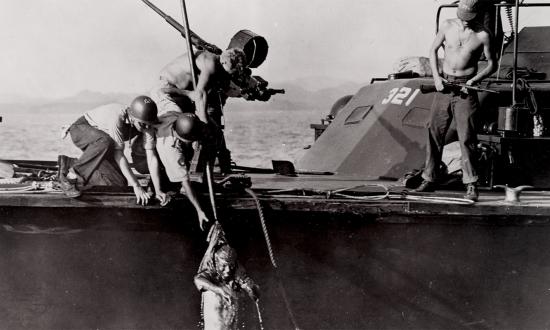 The sailors on board PT-321 fish Japanese survivors out of the water following the Battle of the Surigao Strait. The Japanese suffered heavy losses, including ships damaged and sunk by Coward’s squadron.