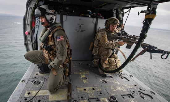 A naval aircrewman and Coast Guard precision marksman in the cabin of an MH-60 Seahawk helicopter from Helicopter Sea Combat Squadron 21 while training off the coast of San Diego. The combination of enduring long hours in cramped positions and vibrations unique to helicopters has made chronic back pain far more prevalent in naval helicopter aircrewmen.