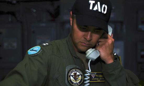 The tactical action officer stands watch in the combat direction center on board the USS Carl Vinson (CVN-70). 