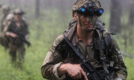 A Marine from Bravo Company, 2d Recon Battalion, 26th Marine Expeditionary Unit, moves through woodland areas during a rainstorm at Pelham Range, Anniston, Alabama. In planning exercises, the Marine Corps must generate realistic weather conditions that cause commanders and staffs to consider the environment as they think through the problems presented.
