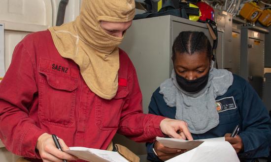 damage controlman (left) reviews a sailor’s personnel qualification standards