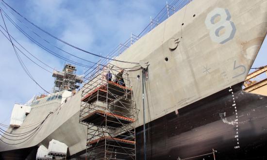 Shipyard workers in San Diego, California, perform upgrades on the forward mooring station of the littoral combat ship USS Montgomery (LCS-8).