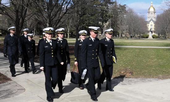 Naval Reserve Officers Training Corps (NROTC) midshipmen walk across the campus of the University of Notre Dame and past the iconic golden dome of the Basilica of the Sacred Heart