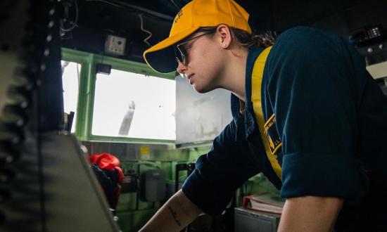 junior officer monitors ship bearing on the bridge