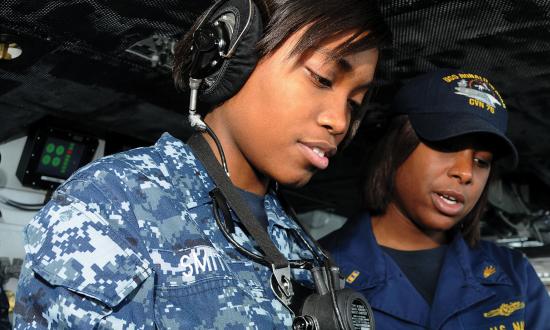 Chief Warrant Officer 2 Lashona Rodgers observes Operations Specialist Seaman Raven Smith as she stands watch on the bridge of the USS Ronald Reagan (CVN-76)