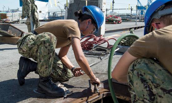 A USS George H. W. Bush (CVN-77) sailor performs corrosive control maintenance on board the ship in Norfolk Naval Shipyard in 2019. Long maintenance availabilities in shipyards are critical to the overall mission of the Navy, but present unique leadership challenges for the ship’s officers and chief petty officers.