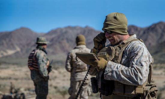 A Marine calls in fire support during a mechanized assault course