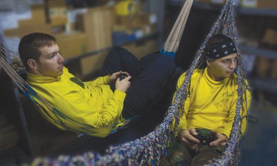 Sailors play video games in a supply office after flight operations aboard the amphibious assault ship USS Boxer (LHD-4).