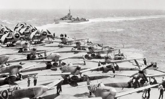 Wielding four aircraft carriers, a battleship, and other warships, the British Pacific Fleet (BPF) delivered “a psychological, as well as a military, blow” to Japan in July–August 1945. Supermarine Seafires (foreground) and Grumman Avengers (background) crowd the armored flight deck of HMS Implacable before a late-war mission.