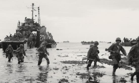 Men of the 6th Marine Division's D Company come ashore at Okinawa, 1 April 1945.