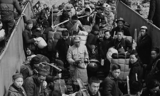 Civilians file aboard a U.S. Navy landing craft as thousands more jam the beaches awaiting evacuation to Taiwan, February 1955.