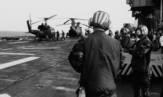 Helicopters are lined up on the deck of the USS Guam (LPH-9) for servicing between missions off the coast of Grenada, 25 October 1983.
