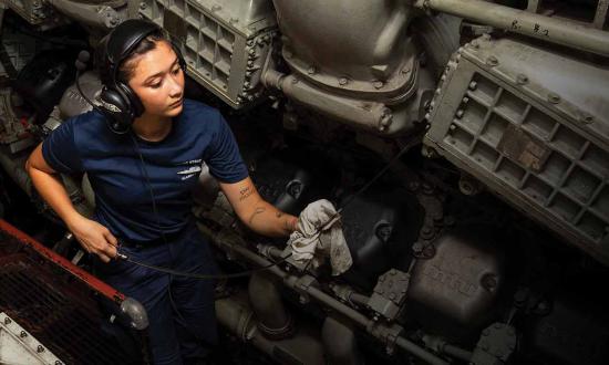 A fireman checks the oil on the main engine of the USCGC Stratton (WMSL-752) in the South China Sea in June 2023. 