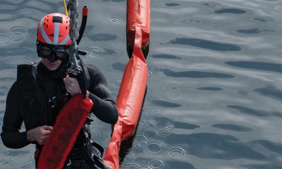 A search-and-rescue swimmer is raised onto the USS Chosin (CG-65). Some personnel redlines include a requirement for two rescue swimmers, without which ships may be unable to sail without flag approval.