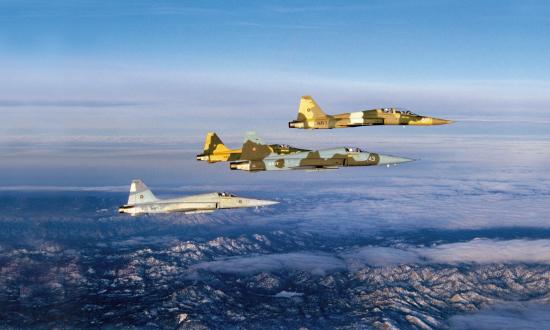Four Navy Fighter Weapons School (TOPGUN) F-5s cruise above Southern California on the way to an early morning showdown with some F-14 Tomcats.