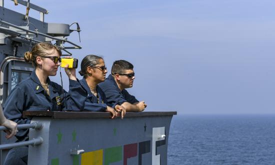 Ensign Veronica Sullivan, left, the gunnery officer on board the guided-missile cruiser USS Normandy (CG-60) takes distance measurements during a replenishment-at-sea evolution.