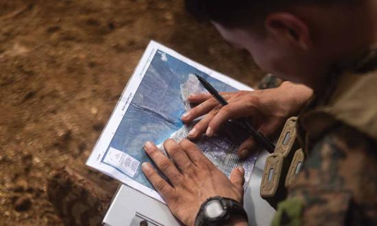An infantryman with 3d Littoral Combat Team, 3d Marine Littoral Regiment, calls for fire during a squad competition in Hawaii in November 2023. Each MLR should incorporate a new component: a multidomain decoy company, within which an electromagnetic decoys platoon would simulate electromagnetic signatures ranging from division-level command-and-control nodes to rifle squads.