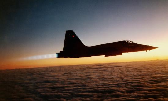 A Navy F-5 in afterburner at sunset